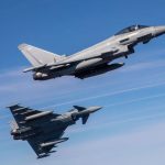 Un par de Jets militares haciendo maniobras en despejado cielo azul