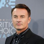 El actor australiano, Julian, posando para las cámaras con un traje negro en la red carpet de los CRITIC CHOICE AWARDS