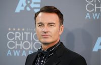 El actor australiano, Julian, posando para las cámaras con un traje negro en la red carpet de los CRITIC CHOICE AWARDS