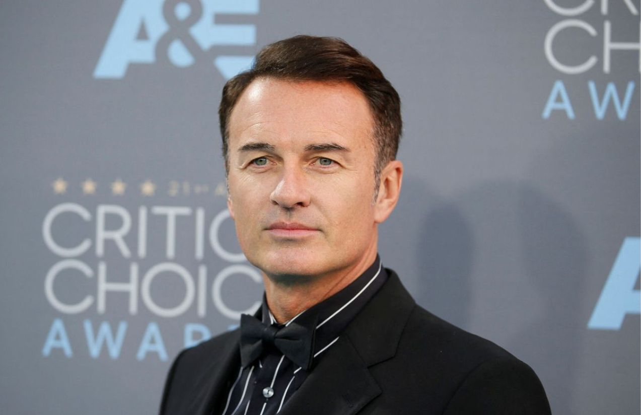 El actor australiano, Julian, posando para las cámaras con un traje negro en la red carpet de los CRITIC CHOICE AWARDS