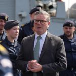 Un hombre con traje hablando con un grupo de militares que lo rodean