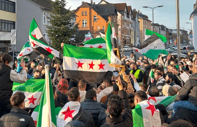 Muchas personas reunidas en procesiones mientras levantan banderas