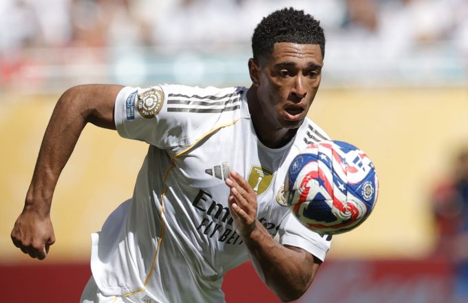 Jude Bellingham running in a Real Madrid uniform, staring intently at a soccer ball